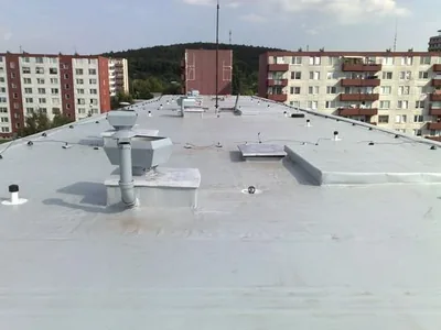 Biela fólia s vetracími hlavicami, v pozadí paneláky