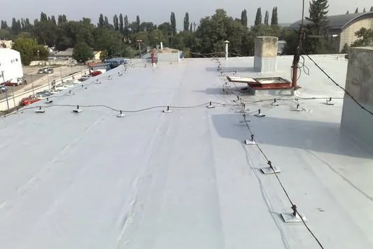 Svetlá fólia s mechanickým kotvením, v pozadí mesto